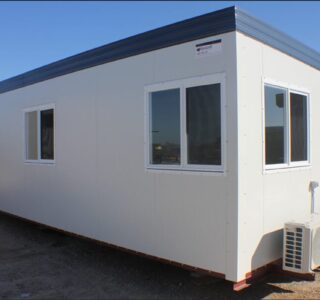 White portable office building with multiple windows and external air conditioning units.
