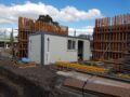 Demountable building unit at a construction site surrounded by building materials